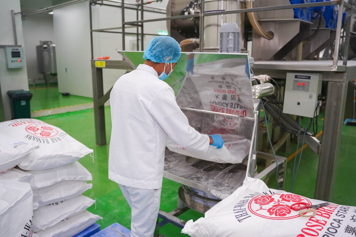 Operator handling sacks of tapioca starch at intake.
